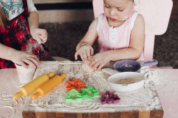 Free photo view from above of cute girls playing with dough at kitchen