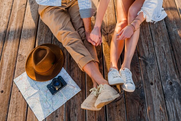 View from above legs of couple traveling in summer dressed in sneakers