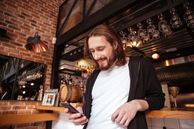 View from below of man on bar with phone