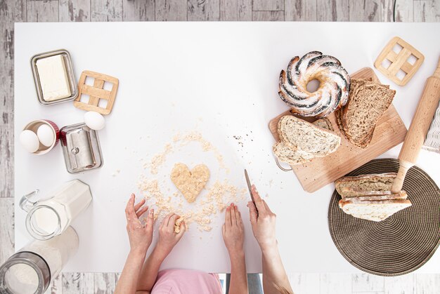 Foto gratuita la vista dall'alto. mamma e figlia preparano pasticcini in cucina.