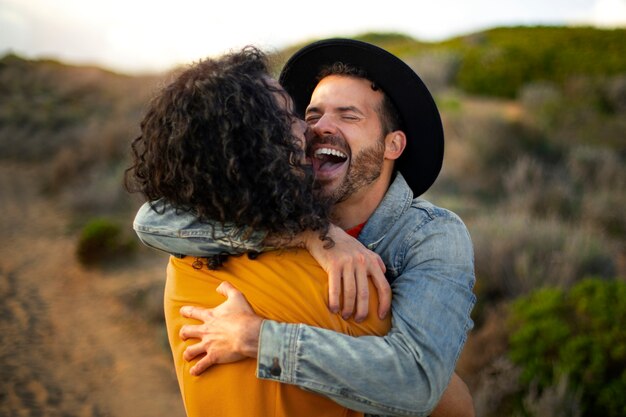 View of gay couple being affectionate and spending time together of the beach