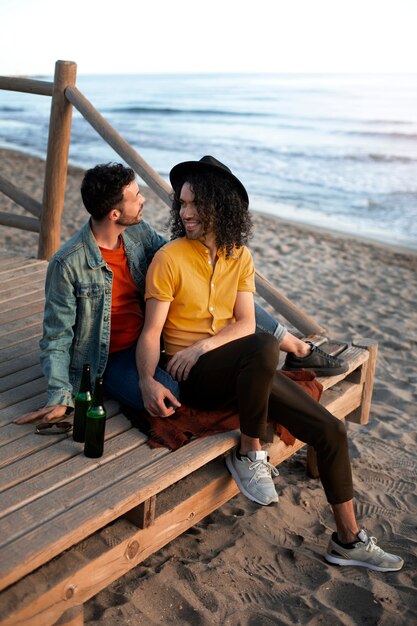 View of gay couple being affectionate and spending time together of the beach