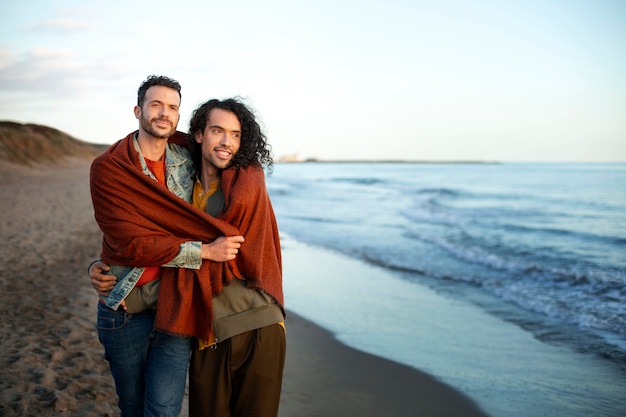 View of gay couple being affectionate and spending time together of the beach