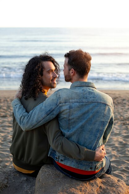 Вид гей-пары, ласковой и проводящей время вместе на пляже
