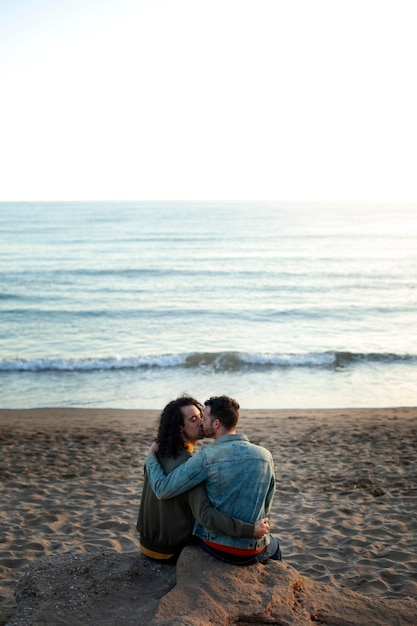 View of gay couple being affectionate and spending time together of the beach