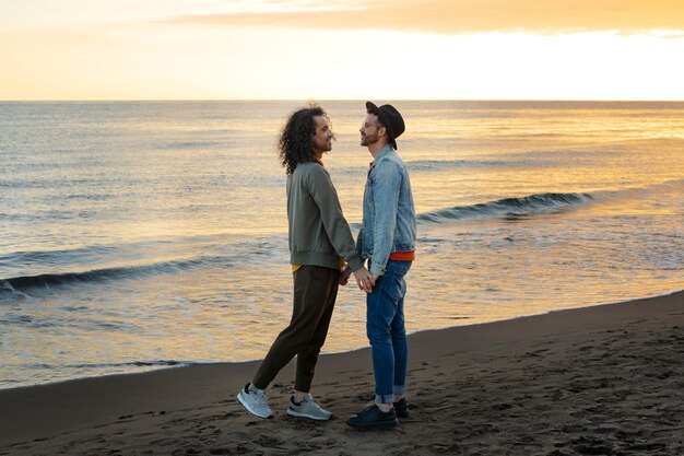 View of gay couple being affectionate and spending time together of the beach