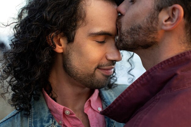 View of gay couple being affectionate and spending time together of the beach