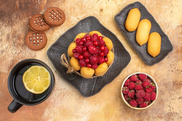 Above view of a gift cake and biscuits on brown plates on mixed color table