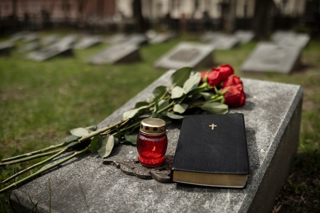 View of gravestone with flowers and candle