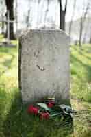 Free photo view of gravestone with flowers and candle