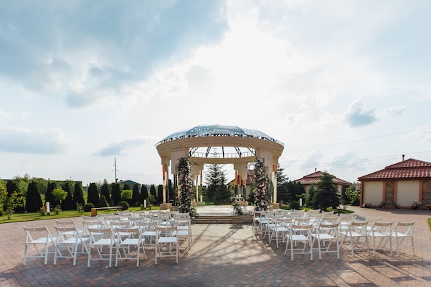 View of guest seats and ceremonial weddding archway on the sunny say