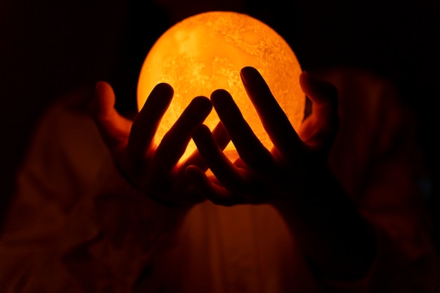 Free photo view of hands holding moon light