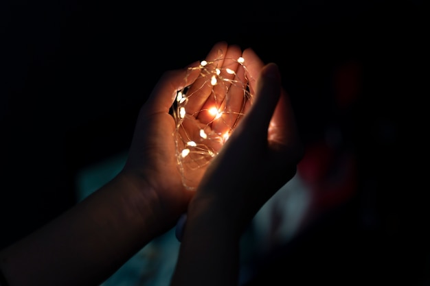 Free photo view of hands tiny lights