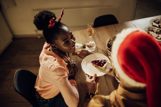 Above view of happy couple having cranberry pie for dessert on Christmas eve