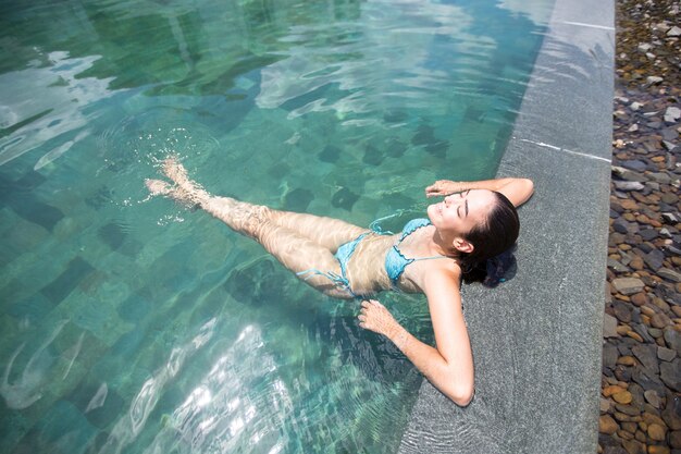 수영장에서 휴식을 즐기는 행복한 여자의보기 위