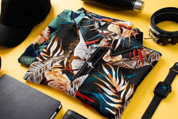 Free photo view of hawaiian shirts with floral print and smartwatch