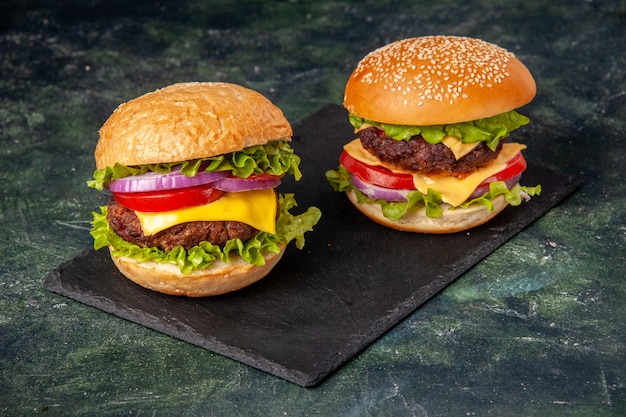 Above view of homemade delicious sandwiches on black board on gray blurred surface