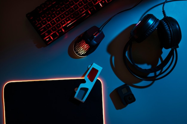 View of illuminated neon gaming keyboard setup and 3d glasses