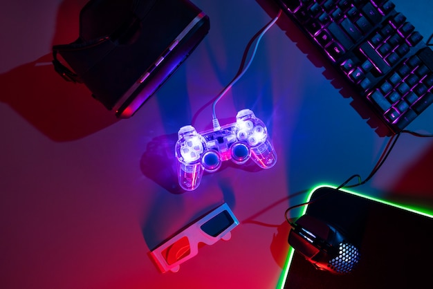 View of illuminated neon gaming keyboard setup and controller