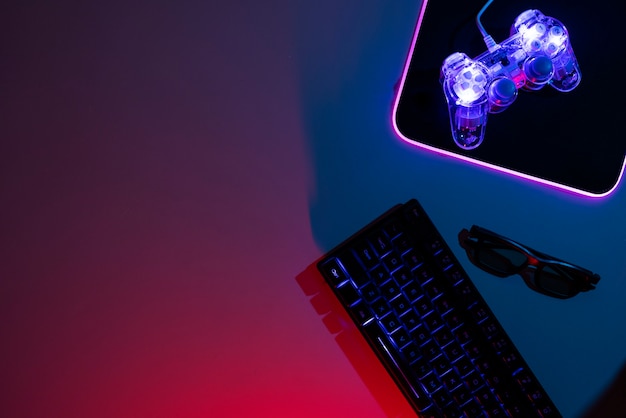 View of illuminated neon gaming keyboard setup and controller