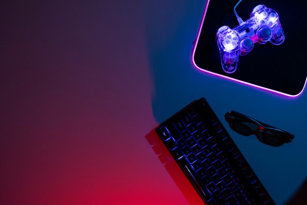 view of illuminated neon gaming keyboard setup and controller