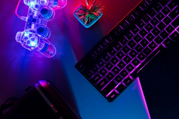 View of illuminated neon gaming keyboard setup and controller