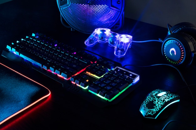 View of illuminated neon gaming keyboard setup and controller