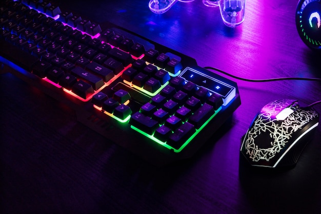 View of illuminated neon gaming keyboard setup and controller