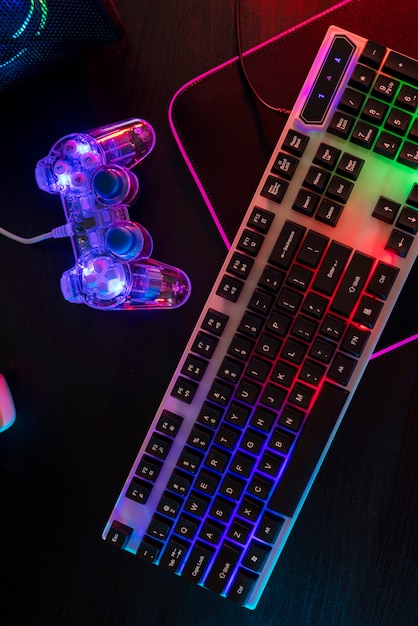 Вид на игровую клавиатуру с неоновой подсветкой и контроллер