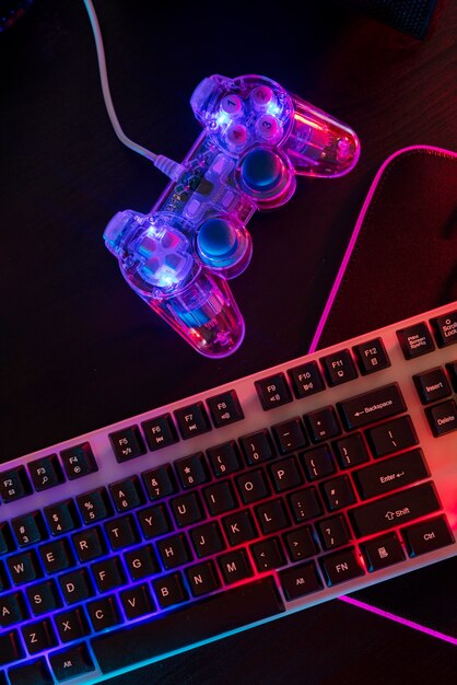 View of illuminated neon gaming keyboard setup and controller