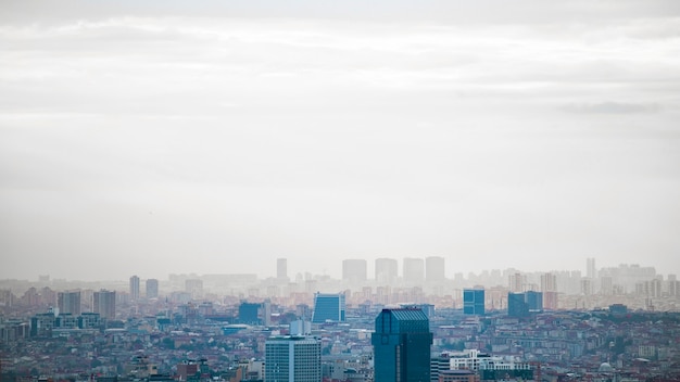 View of the Istanbul at cloudy weather, multiple low and high buildings, fog, Turkey