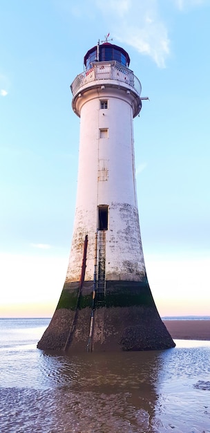 Vista di un faro di liverpool al tramonto, stampe del livello dell'acqua sulla facciata, regno unito