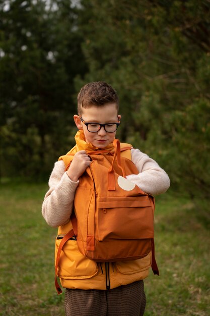 View of little boy with backpack exploring nature