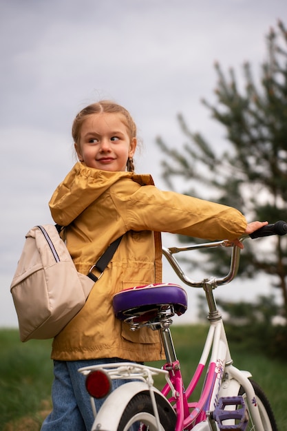 バックパックと自転車で自然の中で冒険する少女の眺め