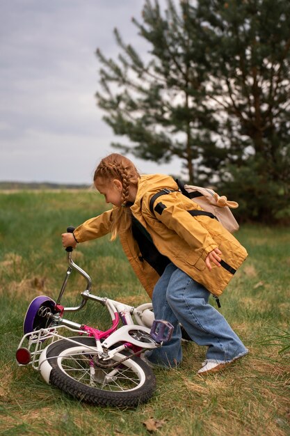 배낭과 자전거를 타고 자연을 모험하는 어린 소녀의 모습