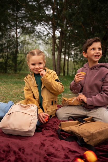 Free photo view of little kids with backpacks spending time in nature outdoors