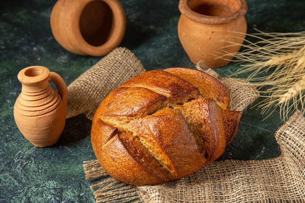 茶色のタオルの上の食餌療法の黒いパンと暗い色の表面の陶器のビューの上