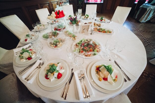 View of many round plates with tasty vegetables dish of salads with tomato onion zucchini tomato and herbs Big delicious for dinner in restaurant