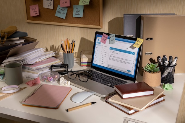 Foto gratuita vista dell'area di lavoro disordinata dell'ufficio con il dispositivo portatile