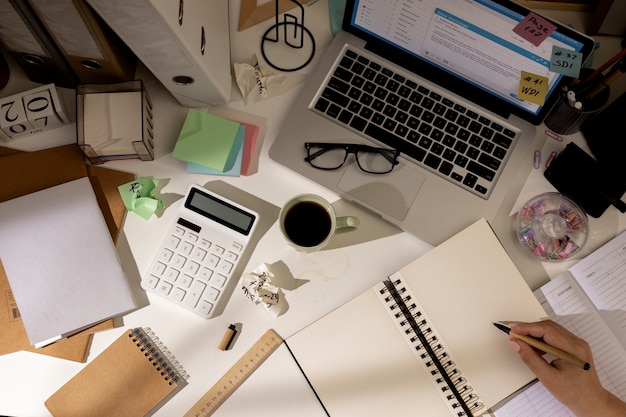 View of messy office workspace with laptop