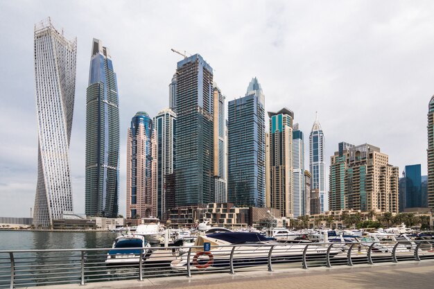 View of modern skyscrapers shining in sunrise lights in Dubai Marina in Dubai, UAE.