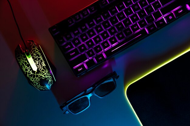 View of neon illuminated gaming desk setup with keyboard