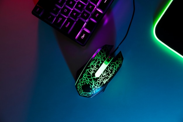 View of neon illuminated gaming desk setup with keyboard