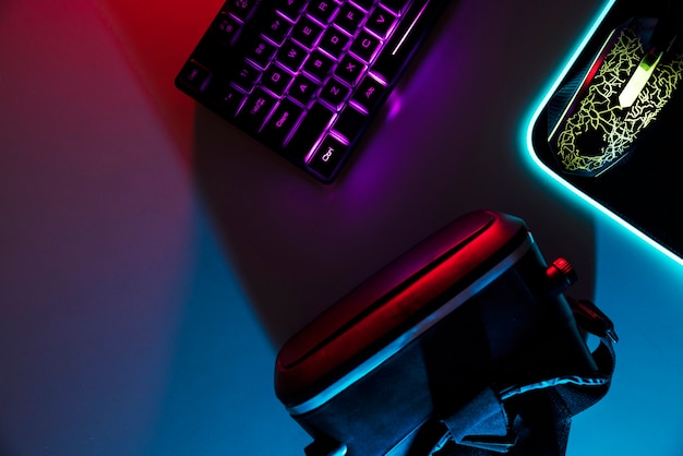 View of neon illuminated gaming desk setup with keyboard