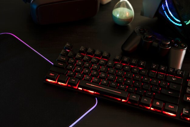 View of neon illuminated gaming desk setup with keyboard