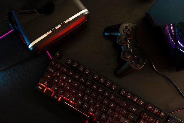 Free photo view of neon illuminated gaming desk setup with keyboard