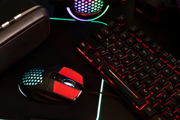 View of neon illuminated gaming desk setup with keyboard