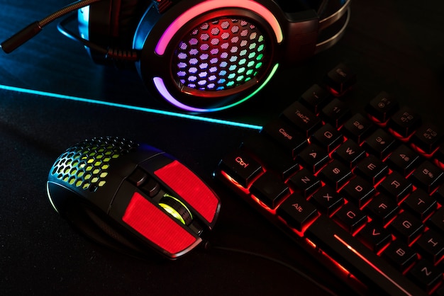 Free photo view of neon illuminated gaming desk setup with keyboard