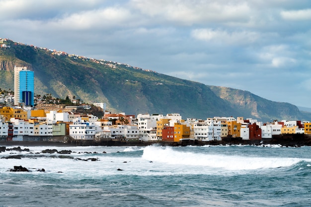 푼타 브라바, 푸에르토 드 라 크루즈, 테 네리 페, 카나리아 제도, 스페인에있는 바위에 바다 해안과 화려한 건물에보기