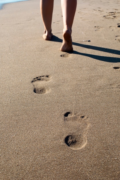Бесплатное фото Вид пляжного песка в летнее время с отпечатками ног